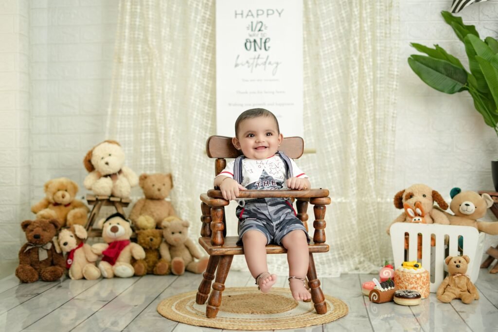 A baby celebrates half birthday indoors with teddy bears, cake, and decorations.